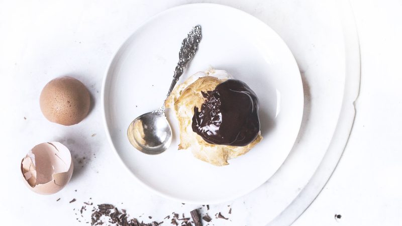 Chocolate profiteroles with vanilla sauce and chocolate slices